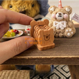 Tiny teddy bear wooden drink coasters with engraved bear faces and matching miniature coaster storage rack, shown as a detailed dollhouse table accessory. Perfect for 1:6 scale miniature kitchen setups, dollhouse coffee corners, tiny tea party scenes and miniature home decor by Real Mini World.