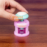 Miniature pink button maker with mint green handle, heart-shaped button parts and silver button shells.