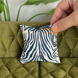 Handcrafted navy blue and ivory zebra print miniature sofa cushion displayed on an olive green tufted dollhouse sofa, luxury miniature furniture decor by Real Mini World.