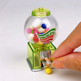 Real functioning translucent green miniature chocolate dispenser from RealMiniWorld — palm-sized gumball machine with colorful chocolates and silver twist handle