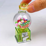 Real functioning translucent green miniature chocolate dispenser from RealMiniWorld — palm-sized gumball machine with colorful chocolates and silver twist handle