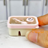 Caja bento en miniatura con cara sonriente