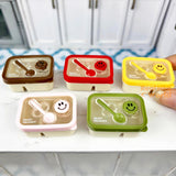 Caja bento en miniatura con cara sonriente