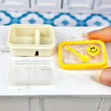 Caja bento en miniatura con cara sonriente