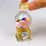 Real functioning translucent yellow miniature chocolate dispenser from RealMiniWorld — palm-sized gumball machine with colorful chocolates and silver twist handle